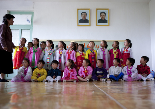 North Korean children in a primary school under the portraits of the Dear Leaders, South Pyongan Province, Chongsan-ri Cooperative Farm, North Korea