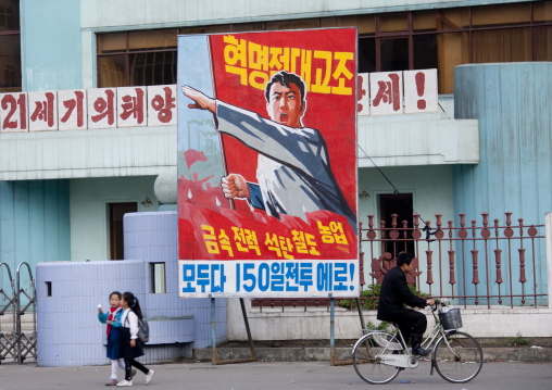 North Korean people in front of propaganda billboard in the street, South Pyongan Province, Nampo, North Korea