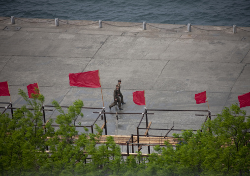 North Korean soldiers walking on the jetty of a harbor, South Pyongan Province, Nampo, North Korea