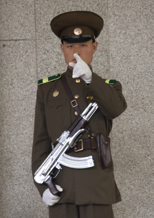 North Korean guard with a silver kalashnikov at the entrance of the international friendship exhibition warning the photographer, North Pyongan Province, Myohyang-san, North Korea