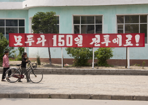 Propaganda slogan for the 150 days of labor campaign on a red billboard in town, North Hwanghae Province, Kaesong, North Korea