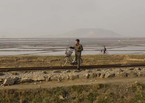North Korean man in a field with a bicycle, South Pyongan Province, Nampo, North Korea