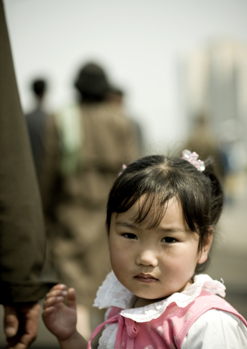 North Korean little girl holding the hand of her father, Pyongan Province, Pyongyang, North Korea