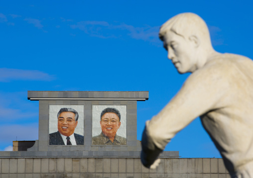 Sport statue in front of Kim il Sung and Kim Jong il portraits, Pyongan Province, Pyongyang, North Korea