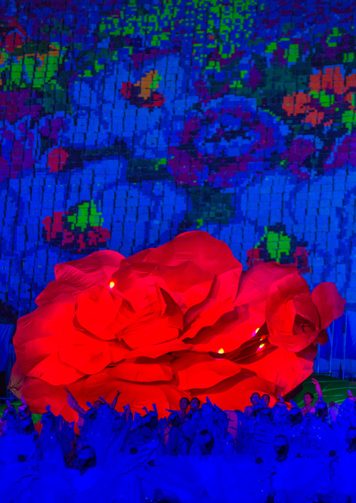North Korean women dancing in front of a giant Kimilsungia flower during the Arirang mass games in may day stadium, Pyongan Province, Pyongyang, North Korea