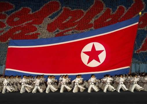 North Korean taekwondo team in front of a giant flag during the Arirang mass games in may day stadium, Pyongan Province, Pyongyang, North Korea