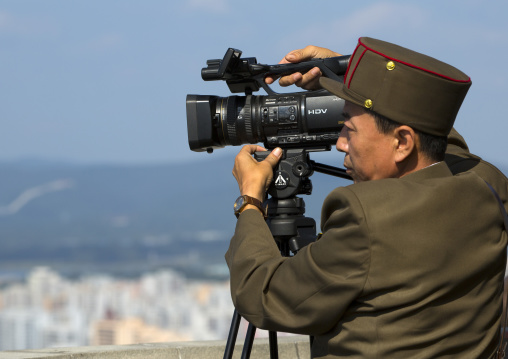 North Korean soldier filming Pyongyang from the top of Juche tower with a sony camera, Pyongan Province, Pyongyang, North Korea
