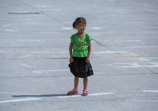 Portrait of a North Korean girl stabding in a square, South Hamgyong Province, Hamhung, North Korea
