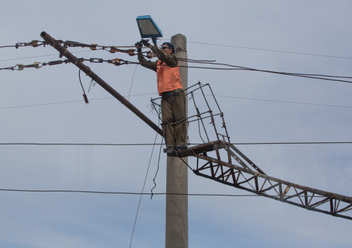 North Korean man repairing electric line, South Hamgyong Province, Hamhung, North Korea