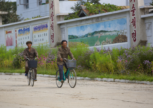 Two North Korean men riding bicycles in a village, South Hamgyong Province, Hamhung, North Korea