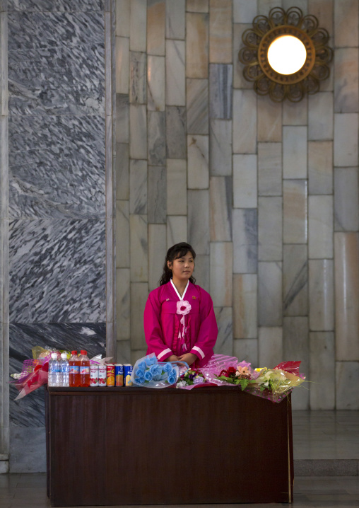 North Korean woman dressed in red choson-ot selling flowers at Mangyongdae children's palace, Pyongan Province, Pyongyang, North Korea
