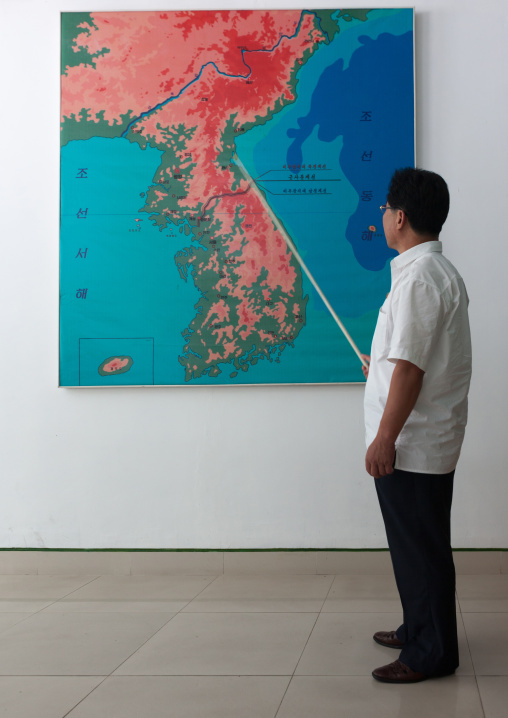 North Korean guide in front of the Korea map on the Demilitarized Zone, North Hwanghae Province, Panmunjom, North Korea