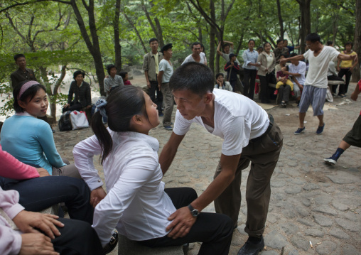 North Korean man inviting a woman to dance in a park, North Hwanghae Province, Kaesong, North Korea