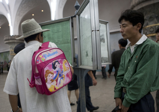 North Korean people reading the offical state newspaper in glory metro station, Pyongan Province, Pyongyang, North Korea