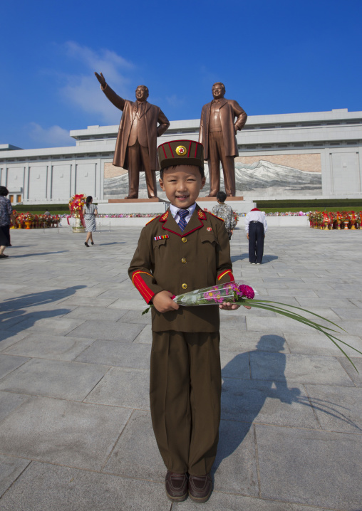 North Korean boy in army uniform paying respect to the two statues of the Dear Leaders in Grand monument of Mansu hill, Pyongan Province, Pyongyang, North Korea