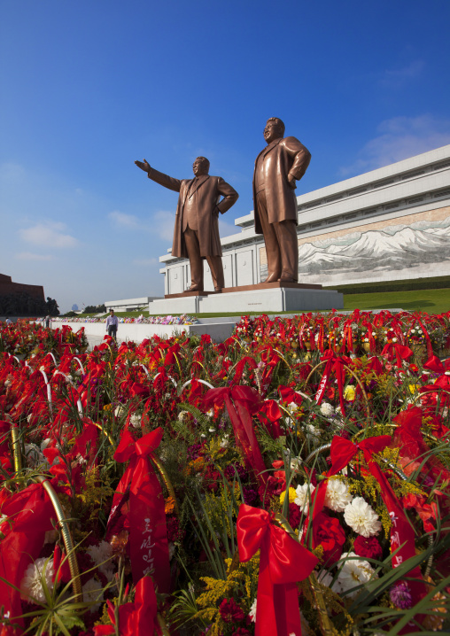 Baskets of flowers in front of the two statues of the Dear Leaders in the Grand monument on Mansu hill, Pyongan Province, Pyongyang, North Korea