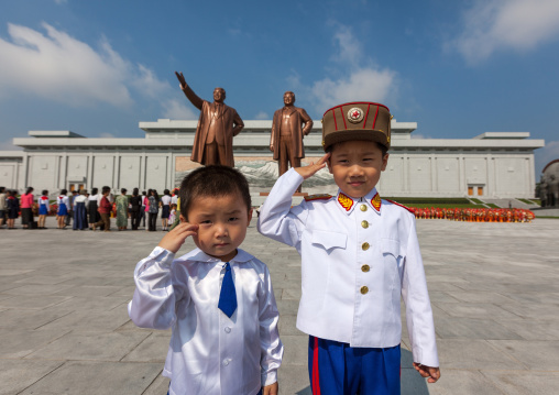 North Korean children saluting like soldiers in front of the statues of the Dear Leaders in Mansudae Grand monument, Pyongan Province, Pyongyang, North Korea