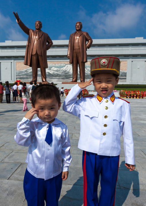 North Korean children saluting like soldiers in front of the statues of the Dear Leaders in Mansudae Grand monument, Pyongan Province, Pyongyang, North Korea