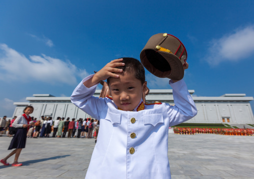 North Korean boy in army uniform putting his kepi in Grand monument of Mansu hill, Pyongan Province, Pyongyang, North Korea