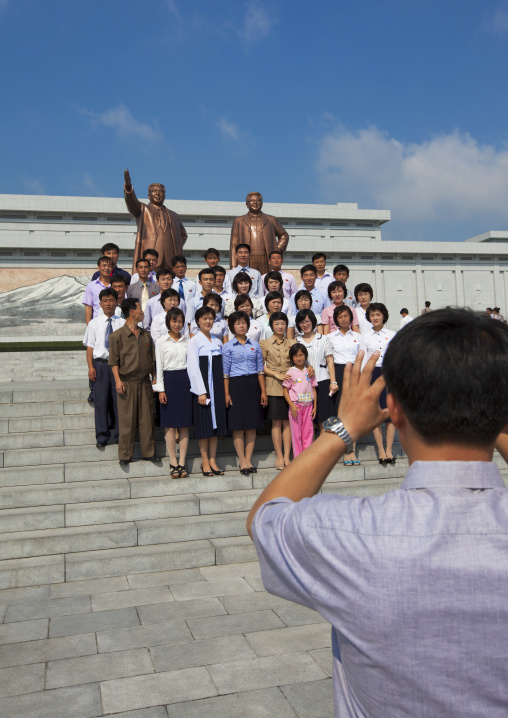 North Korean people posing in front of the two statues of the Dear Leaders in the Grand monument on Mansu hill, Pyongan Province, Pyongyang, North Korea