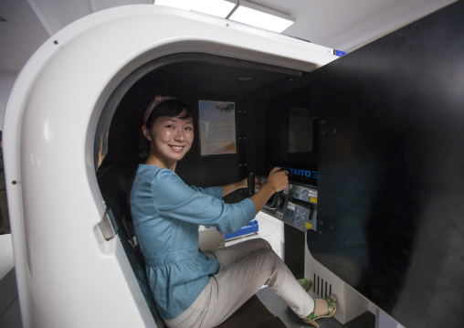 North Korean woman on a car simulator in Kaeson youth park, Pyongan Province, Pyongyang, North Korea
