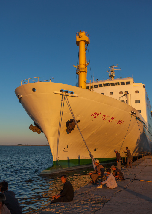 North Korean men fishing in front of a ship in the port, Kangwon Province, Wonsan, North Korea