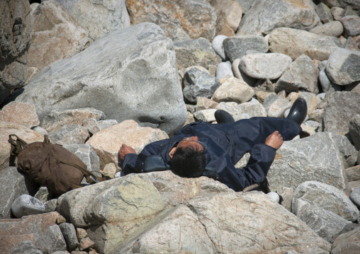 North Korean man sleeping on rocks under the sun, North Hamgyong Province, Chilbo Sea, North Korea