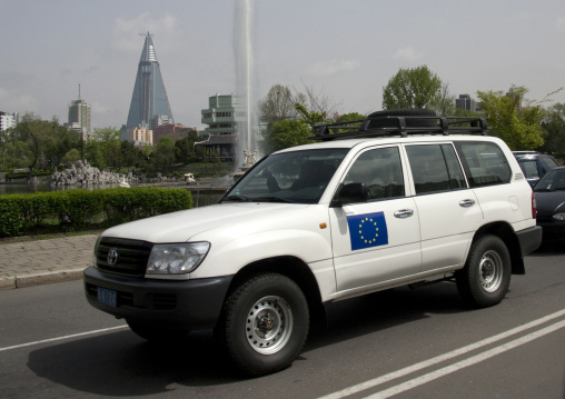 European union official car in the street with the pyramid-shaped Ryugyong hotel in the background, Pyongan Province, Pyongyang, North Korea
