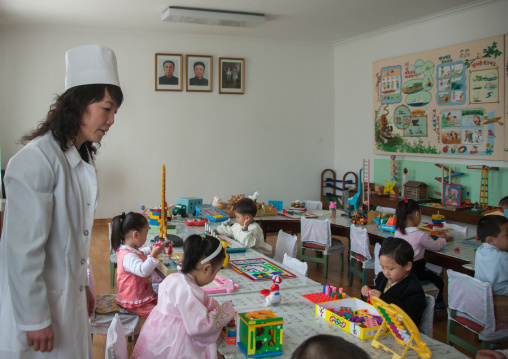 North Korean children in a classroom under the official portraits of the Dear Leaders, Pyongan Province, Pyongyang, North Korea