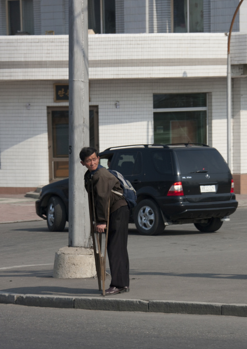 North Korean man with crutches in the street, Pyongan Province, Pyongyang, North Korea
