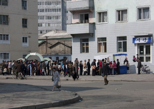 North Korean people queuing to buy food and drinks in a small street shop, Pyongan Province, Pyongyang, North Korea