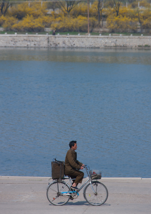 North Korean man riding a bicycle along Taedong river, Pyongan Province, Pyongyang, North Korea