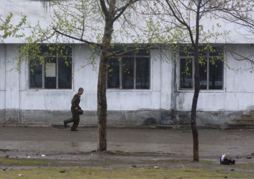 North Korean soldier running in the street under the srain, Pyongan Province, Pyongyang, North Korea
