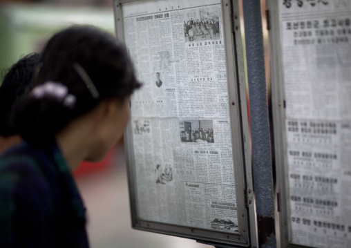 North Korean people reading the offical state newspaper in a subway station, Pyongan Province, Pyongyang, North Korea