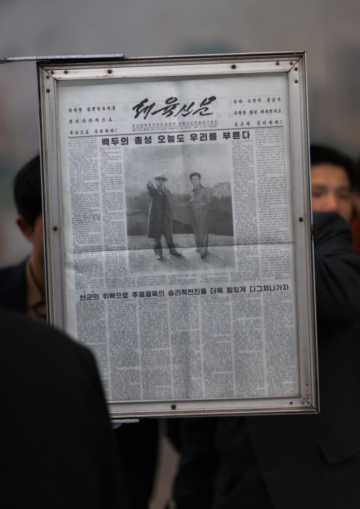 North Korean people reading the offical state newspaper in a metro station, Pyongan Province, Pyongyang, North Korea