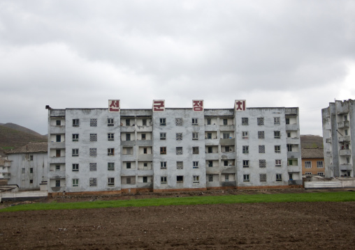 Decrepit building with a propaganda slogan on the top in the countryside, North Hwanghae Province, Kaesong, North Korea