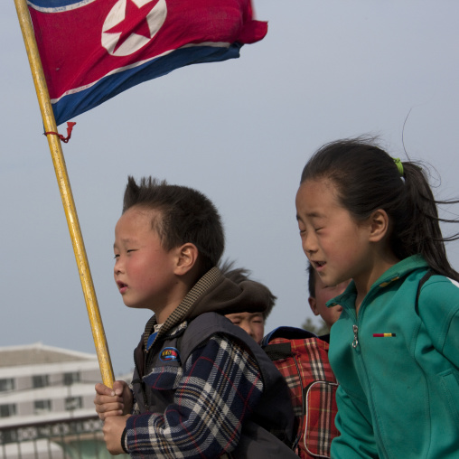 North Korean children parading in the streets on the international workers' day with the national flag, Kangwon Province, Wonsan, North Korea