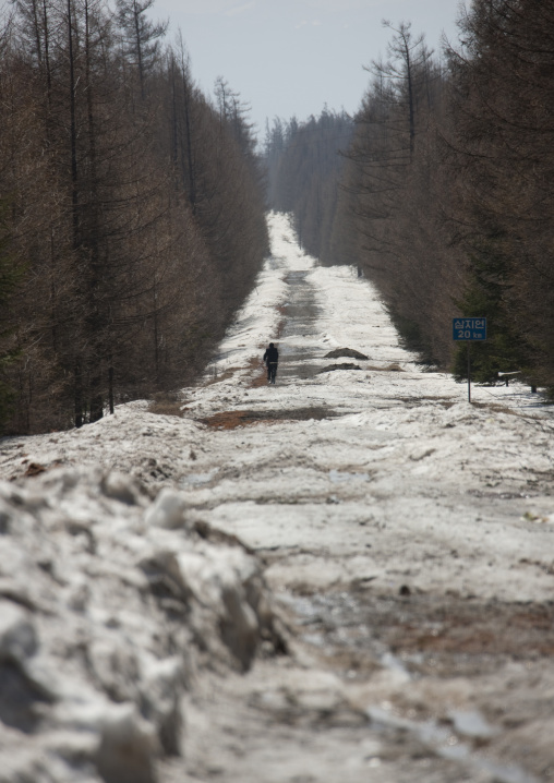 North Korean man riding a bicycle on snowy and icy road, Ryanggang Province, Samjiyon, North Korea
