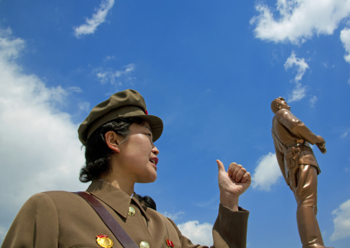 Portrait of a North Korean guide in mount Paektu behind a Kim il Sung statue, Ryanggang Province, Samjiyon, North Korea