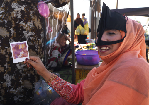 Bedouin Woman Showing A Polaroid Photo In Ibra, Oman