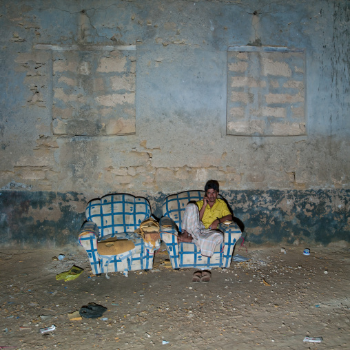 Indian Worker Sitting On Sofa And Answering Telephone, Salalah, Oman