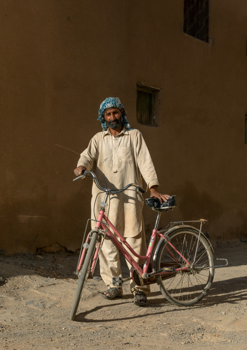 Foreign worker with a bicycle in the street, Ad Dakhiliyah Region, Al Hamra, Oman