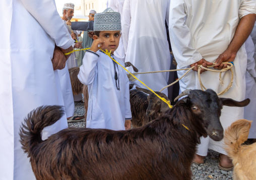 Omani boy in traditional clothing in the cattle market, Ad Dakhiliyah Region, Nizwa, Oman