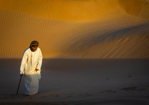 Omani man walking in the rub al khali desert, Dhofar Governorate, Rub al Khali, Oman