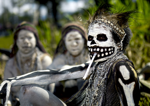 Skeleton tribe woman smoking during a sing sing, Western Highlands Province, Mount Hagen, Papua New Guinea