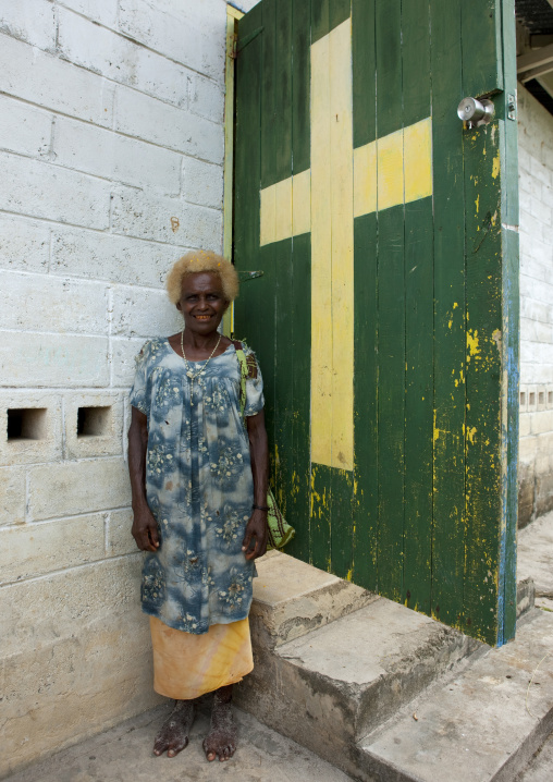 Old woman in front of a church entrance, New Ireland Province, Langania, Papua New Guinea
