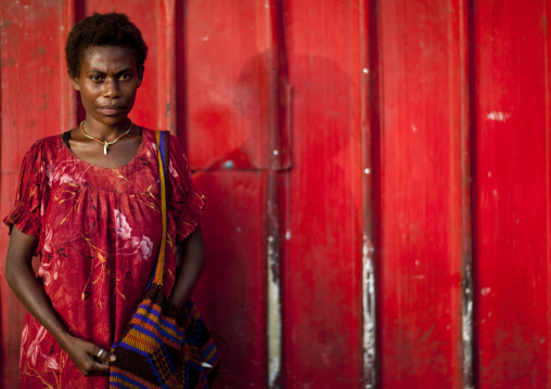 Woman in front of a red wall, East New Britain Province, Rabaul, Papua New Guinea