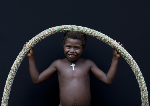 Girl holding a giant shell money, East New Britain Province, Rabaul, Papua New Guinea