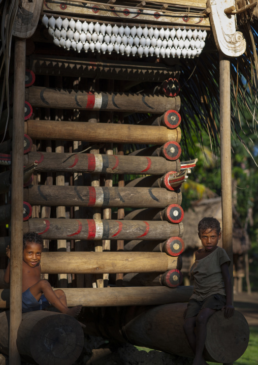 Boys in front of a yam house in a village, Milne Bay Province, Trobriand Island, Papua New Guinea