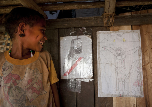 Girl looking at jesus christ drawings on a wall, Milne Bay Province, Trobriand Island, Papua New Guinea